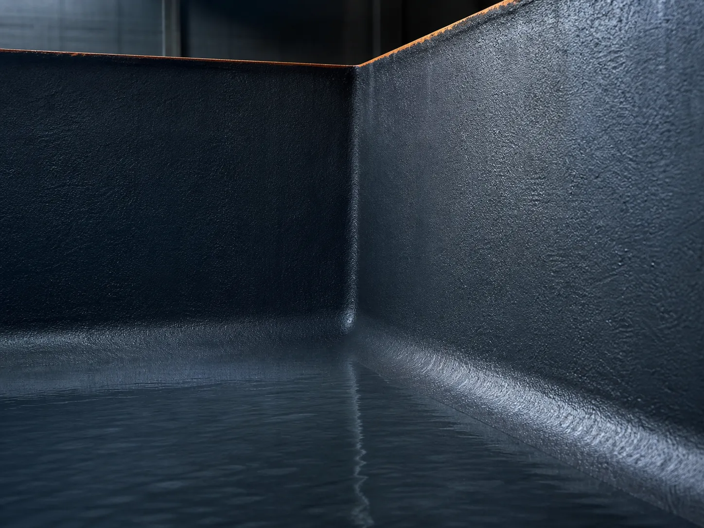Seamless polyurea lining wrapping continuously around an internal containment corner